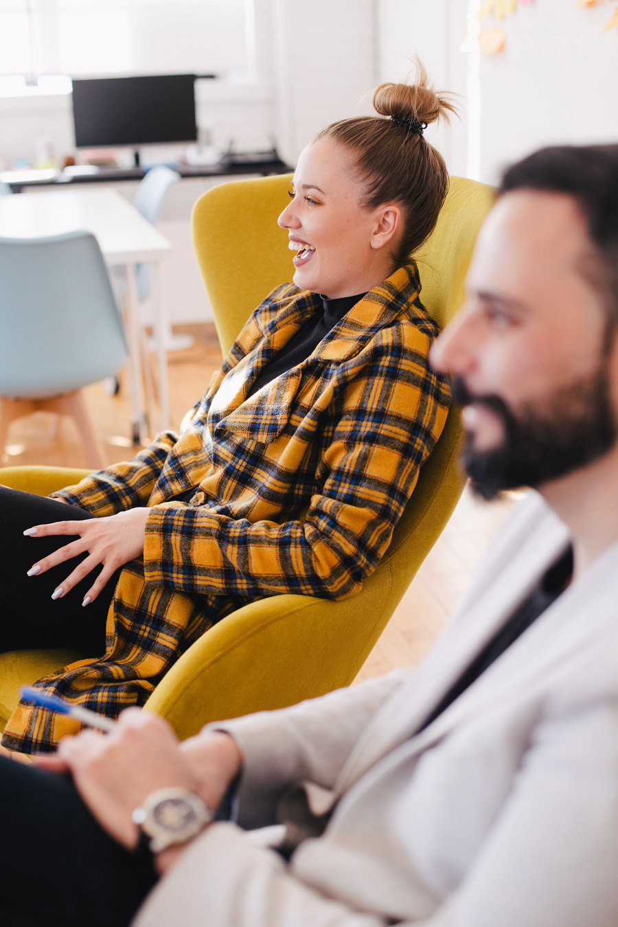 woman sitting on armchair and laughing